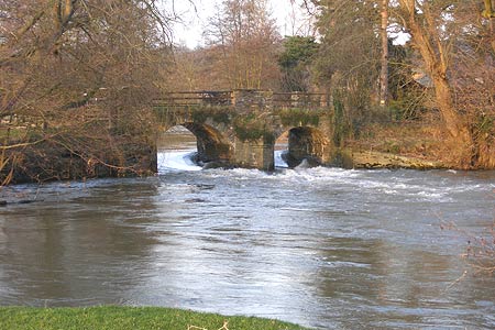 Eaton Hall Farm Bridge and weir with the river in spate